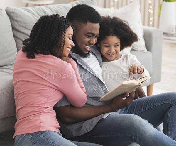 family reading the bible on the floor